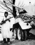 Боец Красной Армии у бронеавтомобиля БА-10М. Юго-западный фронт, зима 1943 года. Машина имеет белую маскировочную окраску, на корме корпуса закреплён инструмент и вездеходные цепи "Оверолл".