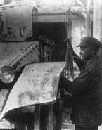 Монтаж левого переднего подкрылка на опытный танк БТ-2-ИС выполняет слесарь-ударник Анисифоров.