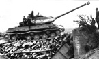 Ещё один танк ИС-2 (тактический номер «434») из состава польского 4-ого тяжёлого танкового полка, пересекает тот же мост из сложенных фашин. Также обращает на себя внимание отсутствие 5-го катка, потерянного в бою. Кроме того башня этого танка в отличие от танка с тактическим номером «424» по периметру окрашена белой полосой и белом крестом для опознавания союзной авиацией. Восточная Пруссия, апрель 1945 года.