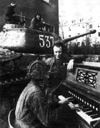 Боец Б.В. Калякин играет классическую музыку своему экипажу (командир танка ИС-2 с тактическим номером "537" гвардии лейтенант В.И. Дегтярев). 1-й Украинский фронт, 87-й отдельный гвардейский тяжелый танковый полк. Бреслау, апрель 1945 года.