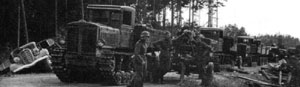 Советская колонна - тягачи "Коминтерн" с зенитными пушками захвачена немцами. Левее - сброшенный с дороги легковой автомобиль ЗиС-101. Лето 1941 года.