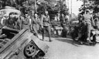 Первый день войны - немецкие мотоциклисты с интересом рассматривают первых советских военнопленных. Слева виден брошенный артиллерийский тягач "Комсомолец". Снимок сделан днём 22 июня 1941 года в полосе наступления 36-й моторизованной дивизии.