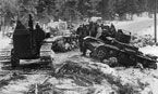 Эвакуация подорвавшихся на минах танков трактором С-60. Обращает на себя внимание, что Т-26 образца 1933 года перекрашены в белый цвет, а ОТ-26, стоящий на обочине, нет. Карельский перешеек, декабрь 1939 года.