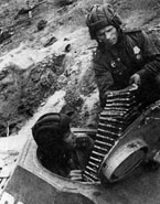 Загрузка ленты с 20-мм патронами в танк. Ленинградский фронт, 1943 год.