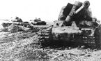 Немецкий солдат осматривает подбитый тяжёлый танк ИС-2. Танк по всей вероятности был поражён в боковую броню, т.к  у него не видно каких-либо повреждений лобовой части. У ИС-2 сдетонировал боекомплект.
