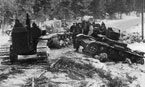 Эвакуация подорвавшихся на минах танков трактором С-60. Обращает на себя внимание, что Т-26 образца 1933 года перекрашены в белый цвет, а ХТ-26, стоящий на обочине, нет. Карельский перешеек, декабрь 1939 года.