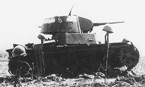 Сгоревший танк Т-26 из состава 18-го механизированного корпуса. Район Умани. Август 1941 г. Каски на винтовках установлены немцами на могилах экипажа танка