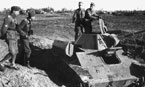 Офицеры Вермахта осматривают подбитый советский танк Т-70. Люк с жалюзи для доступа к двигателям откинут. Лето 1942 года.