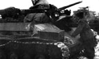 Немецкие танкисты готовят к бою трофейный советский танк Т-70М. На лобовом листе корпуса закреплён государственный флаг нацистской Германии для опознавания машины во время боя. Зима 1943 года.
